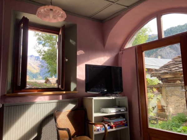 Le petit salon avec la collection de films, la grande banquette bleue et la vue sur la Tête du Longet
