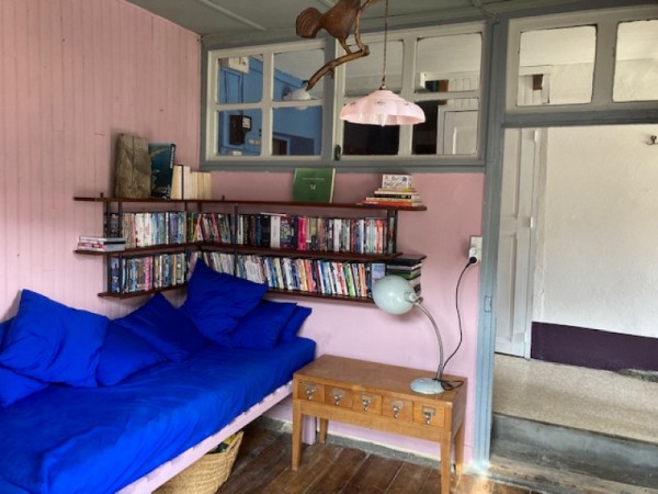 Le petit salon avec la collection de films, la grande banquette bleue et la vue sur la Tête du Longet